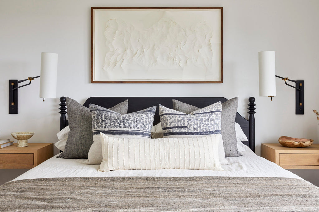 Ivory embroidered extra long lumbar pillow on bed with decorative cushions and neutral-toned bedding in modern bedroom