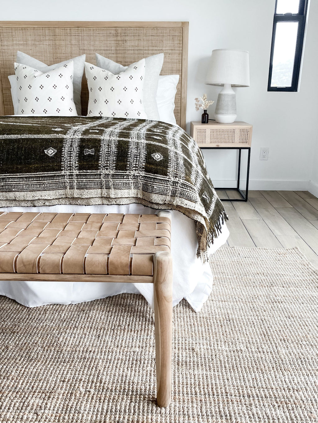 Handwoven Bhujodi Blanket dark brown draped on bed with white pillows in modern bedroom setting