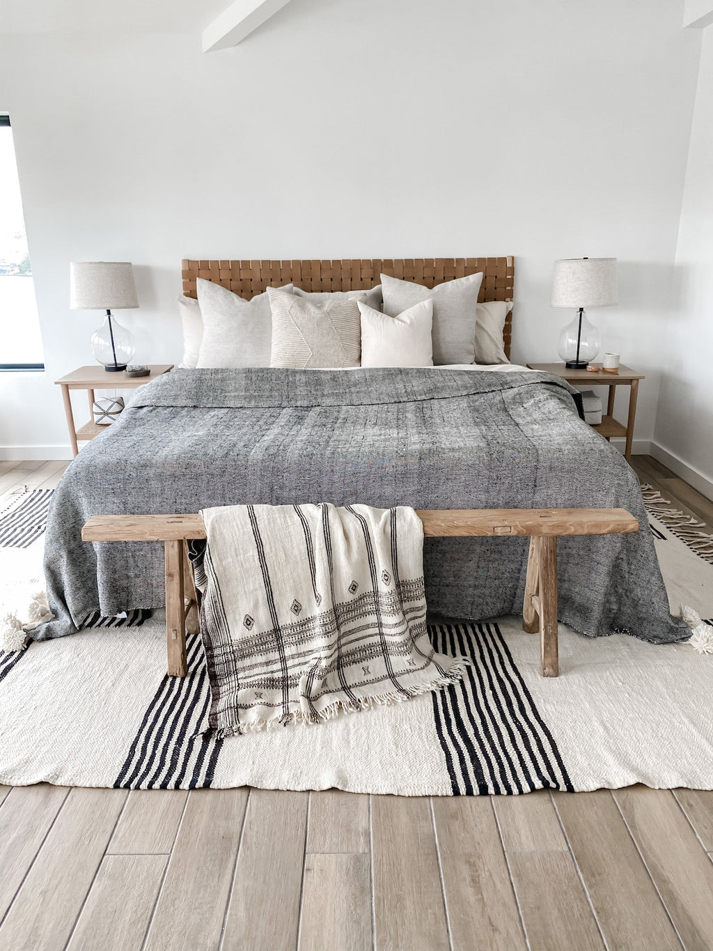 Natural linen pillows arranged on a bed with neutral bedding in a minimalist bedroom