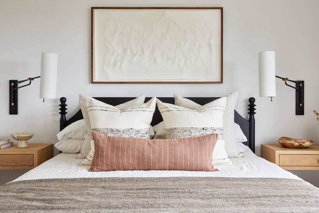Styled Natural Linen PIllows and Grey Stripe Handwoven Columbian Pillow and Rust Embroidered Extra Long Lumbar Pillow in a neutral toned bedroom. - Saffron and Poe