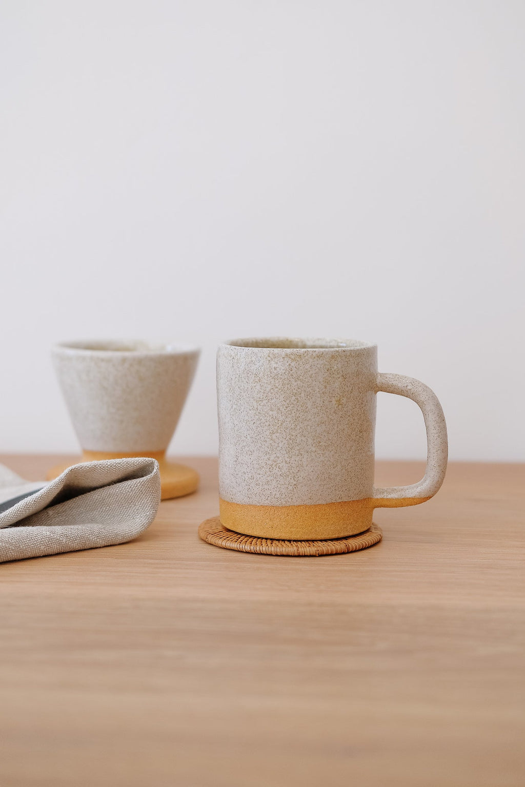 Set of 4 handwoven Tenganan Coasters made from natural Ata reed under ceramic cup on wooden table