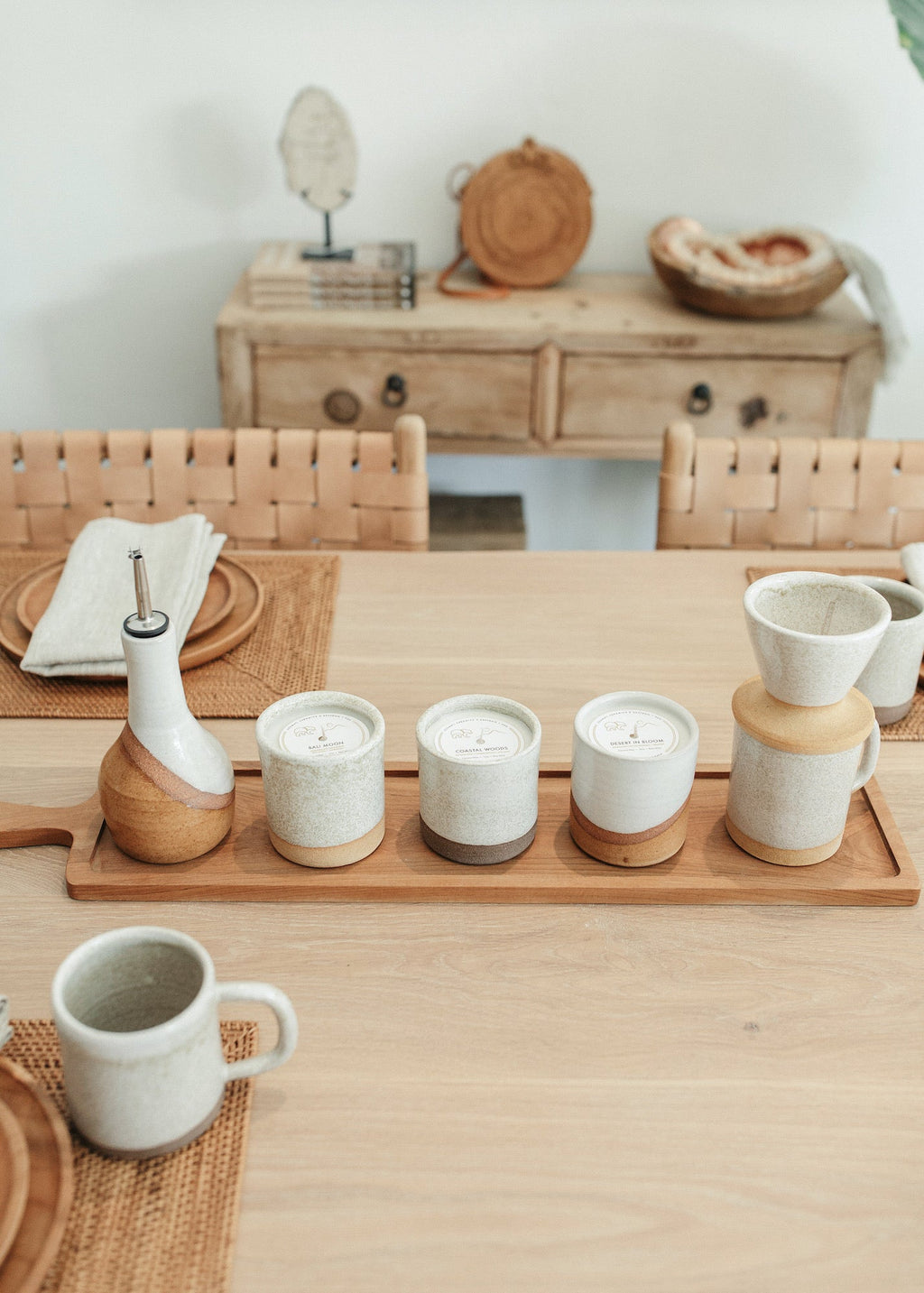 Uzumati Ceramic Olive Oil Bottle with white glaze top and rust stoneware base on wooden tray in rustic kitchen setting