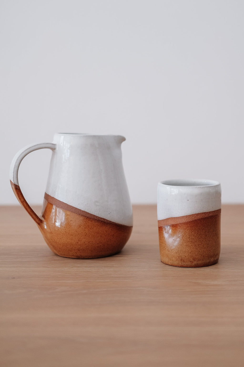 Uzumati Drifter Tumbler with white and rust stoneware on wooden surface