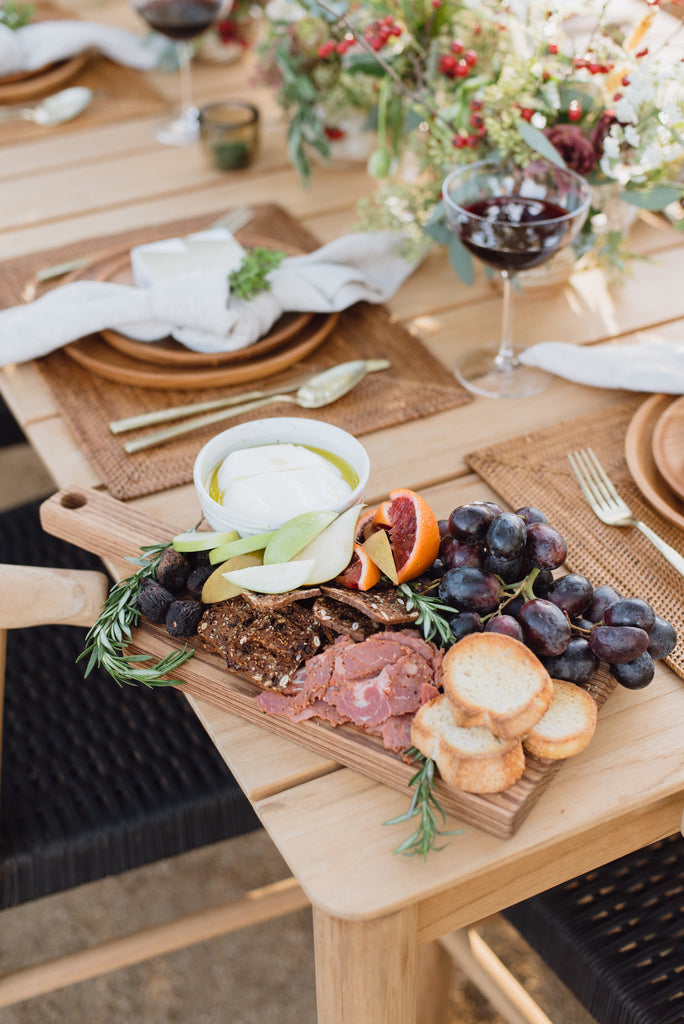 Studio Inko Zebrawood Serving Board on an outdoor table setting with charcuterie, Teak Plates and Tenganan Placemats. - Saffron and Poe