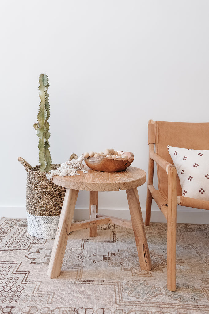 Styled Vintage Elmwood Side Table - Round on a Vintage Turkish Oushai Rug next to a Leather Slingback Lounge Chair - Saffron and Poe