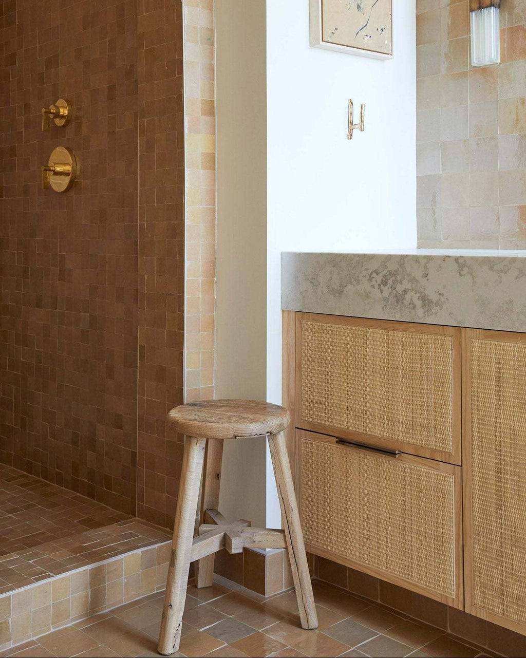 Vintage round wooden stool with rustic patina in a bathroom setting