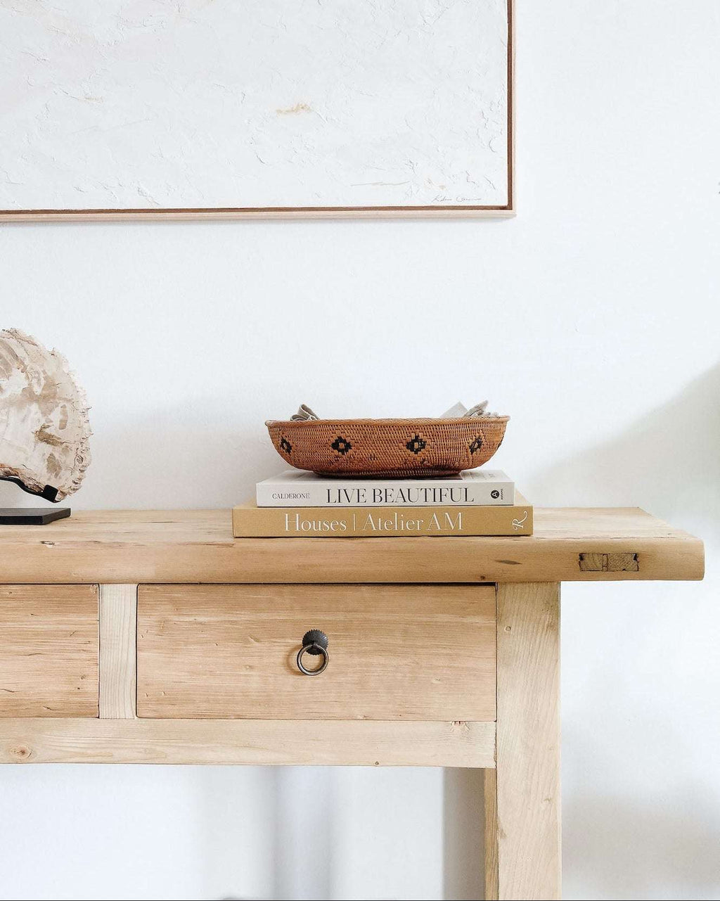 Vintage cypress storage console with three drawers and black metal pulls in minimalist room setting