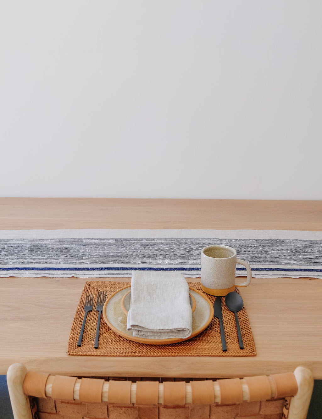 Vintage striped indigo and cream table runner on wooden dining table with rustic place setting