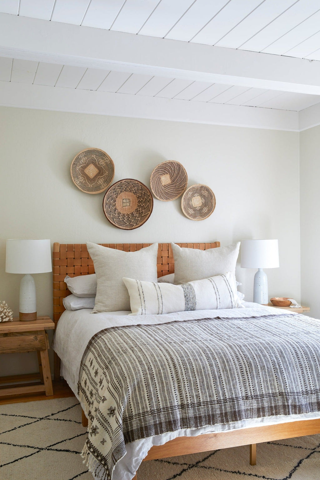 Ilala Palm Wall Baskets displayed in a bedroom above bed with neutral decor and textured bedding