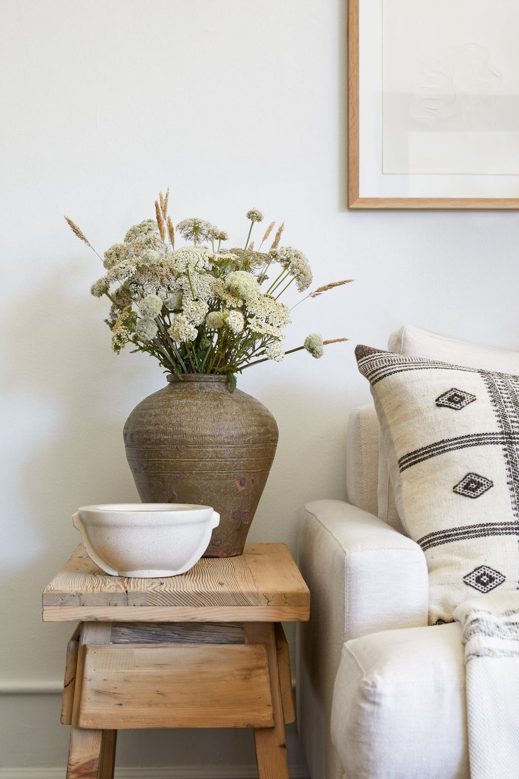 Handmade terrazzo vessel bowl on wooden side table next to sofa with decorative pillow