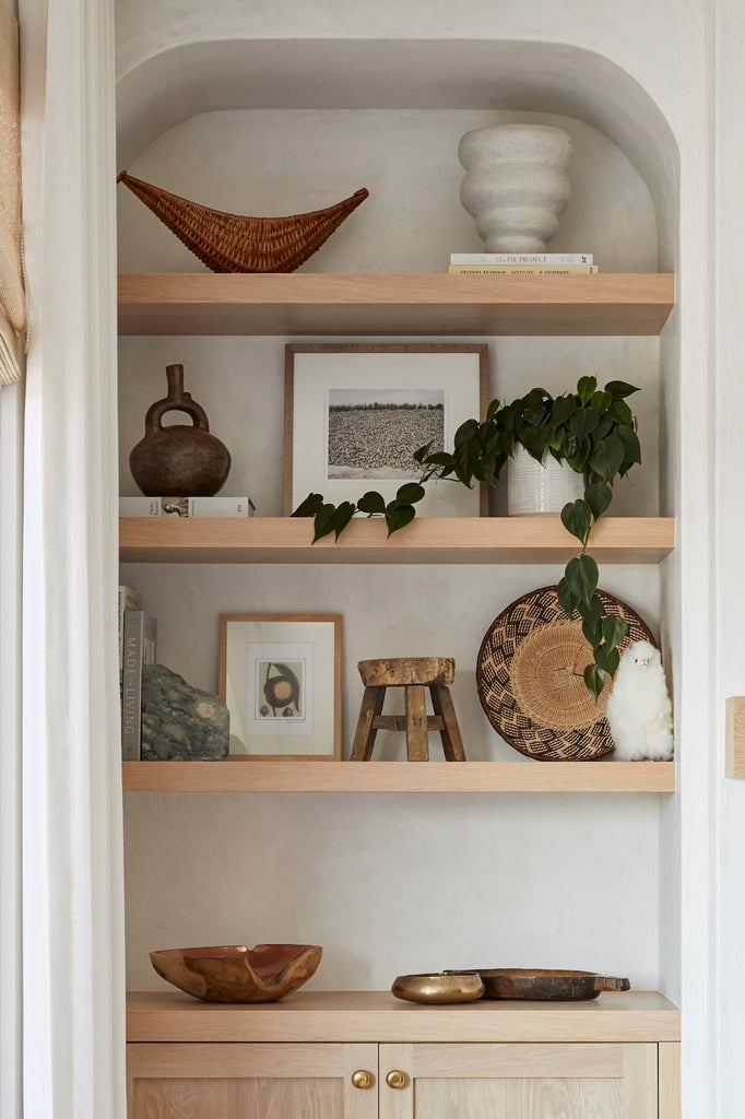 Styled photo of Alpaquita on a shelf with an Ilala Palm Wall Basket and Hammered Copper Bowl. - Saffron + Poe