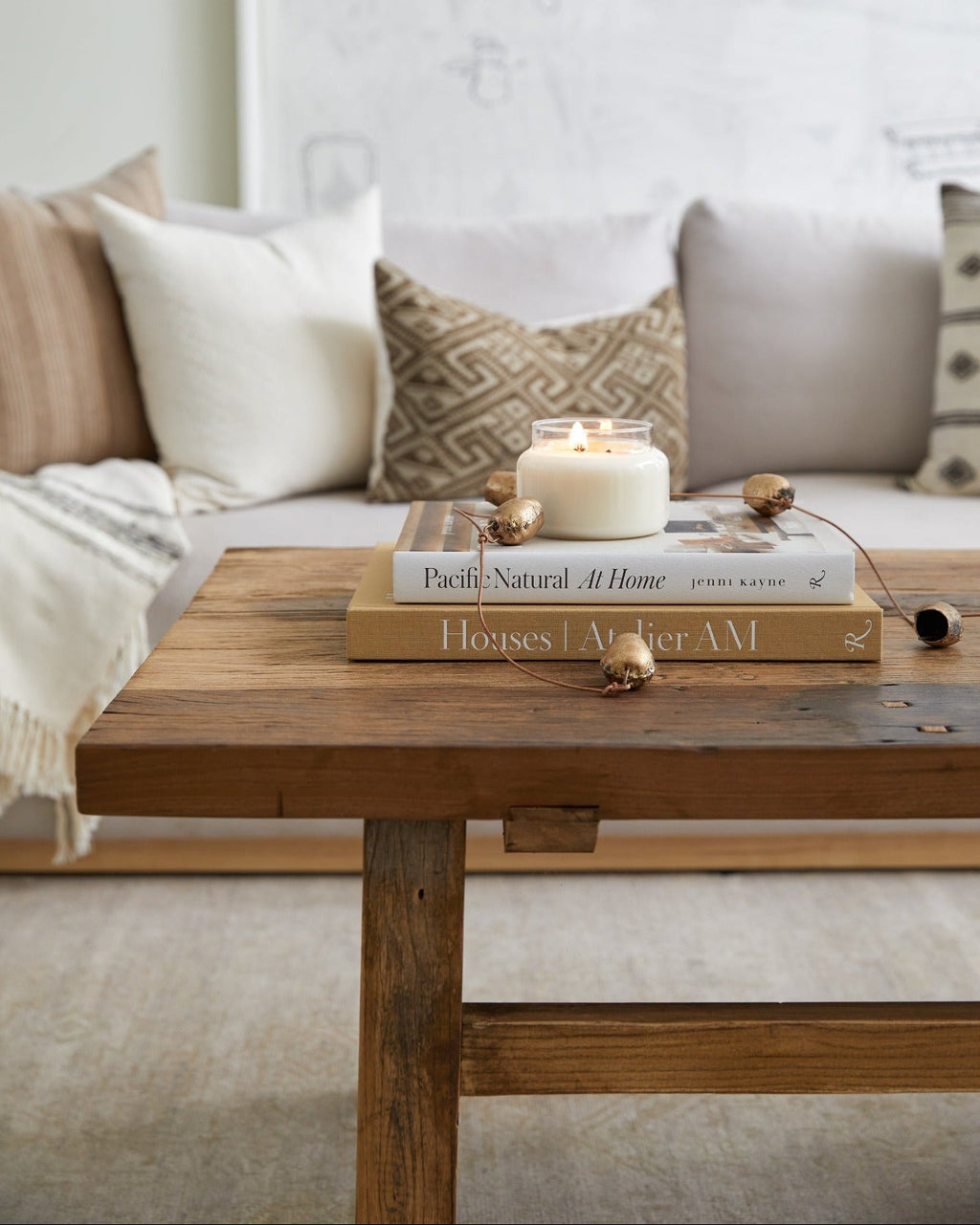 Vintage wood coffee table made of dark elm with books and a candle on top in a cozy living room setting
