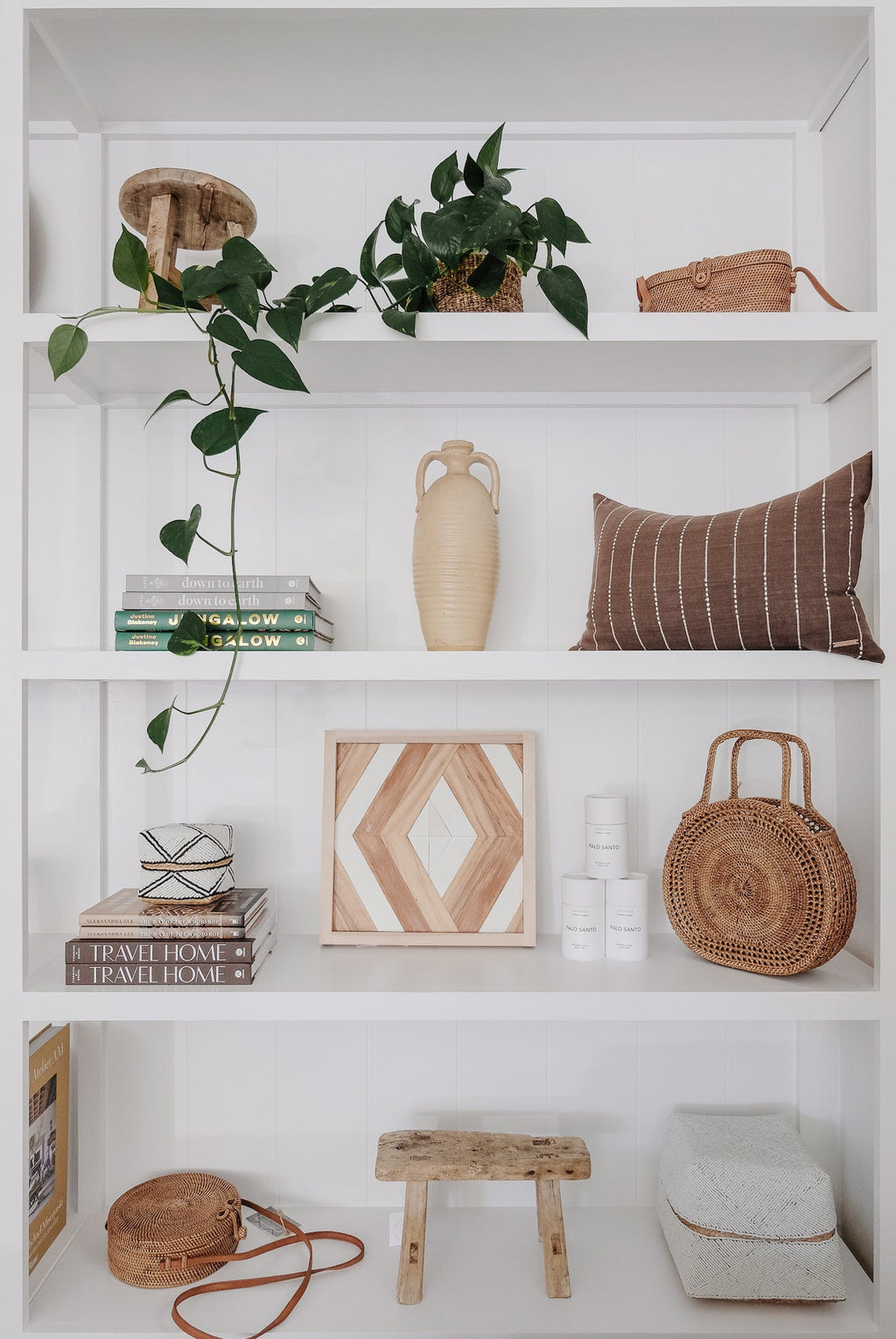 Tenganan Basket Handbag displayed on white shelves with decor and plants in a modern minimalist setting