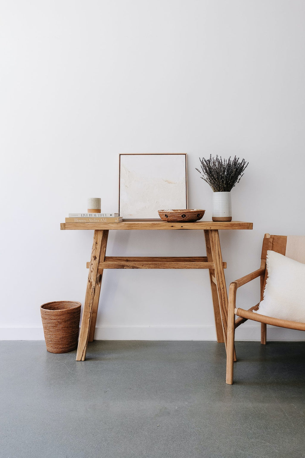 Woven Tenganan waste basket made from natural Ata reed next to wooden desk in minimalist room