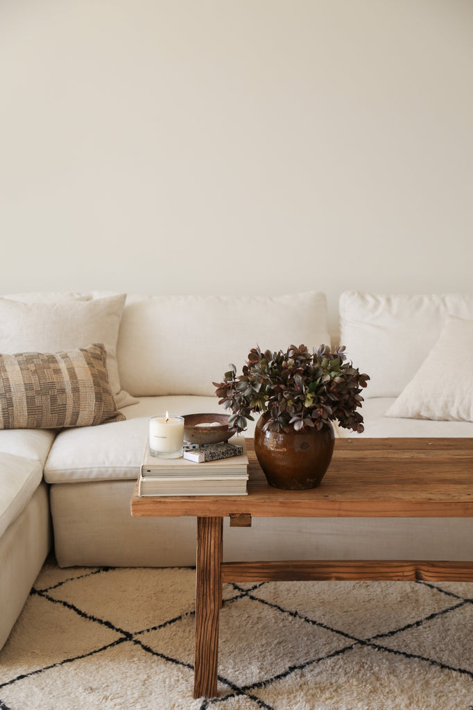 Styled view of Vintage Wood Coffee Table in a living room setting on a Beni Ourain Rug. - Saffron + Poe