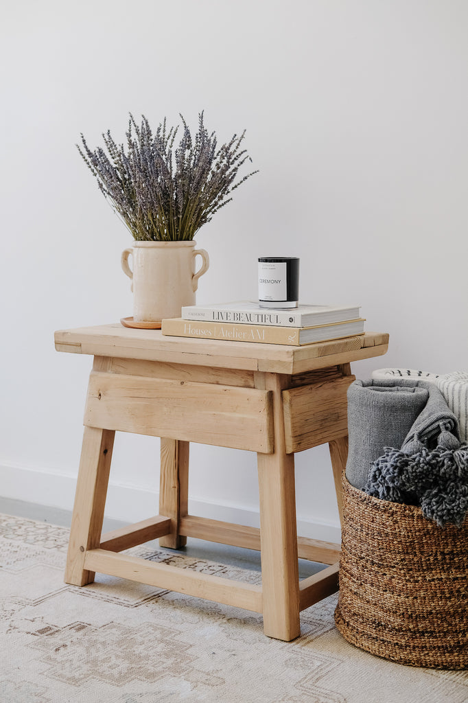 Styled view of Vintage Cedar End Table with a handwoven basket and moroccan blankets. - Saffron + Poe