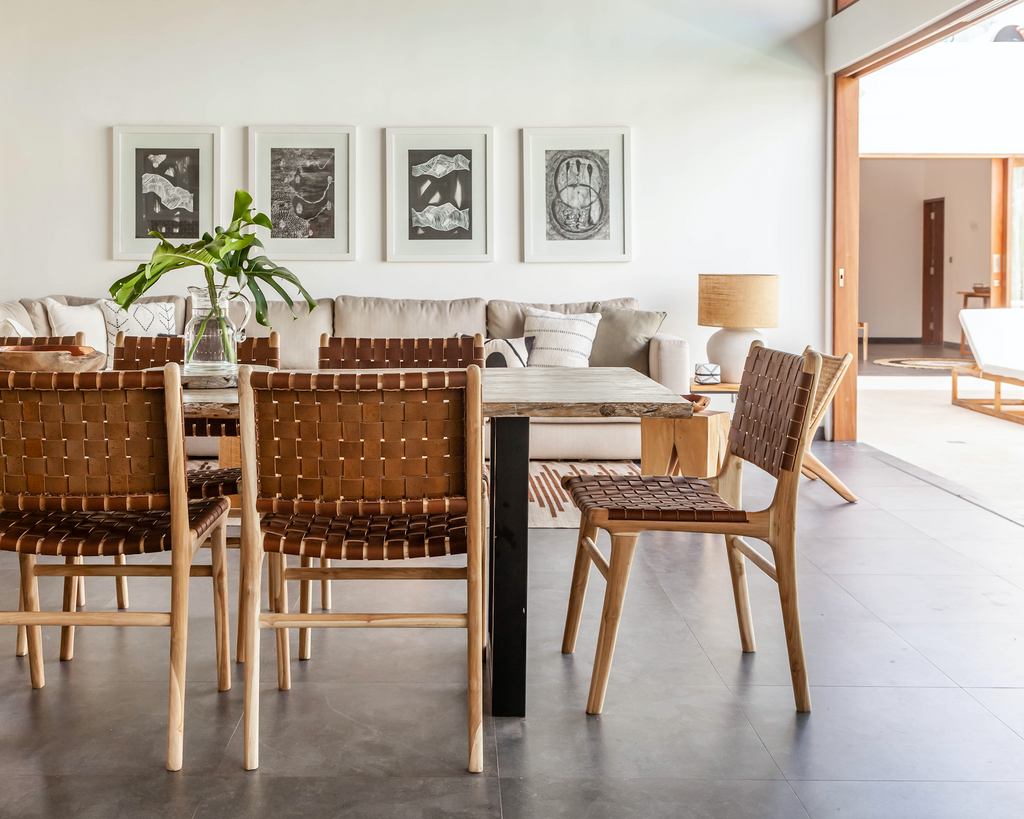 Woven leather dining chairs with teak wood frames in a modern dining room setting