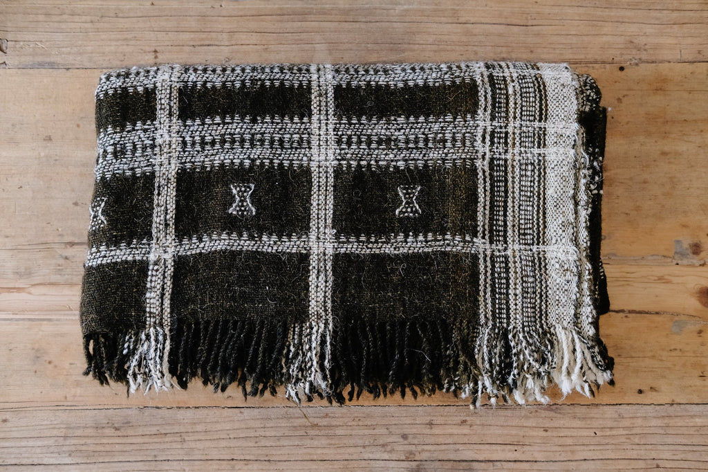 Handwoven Bhujodi Blanket dark brown wool with woven pastoral motifs on wooden background