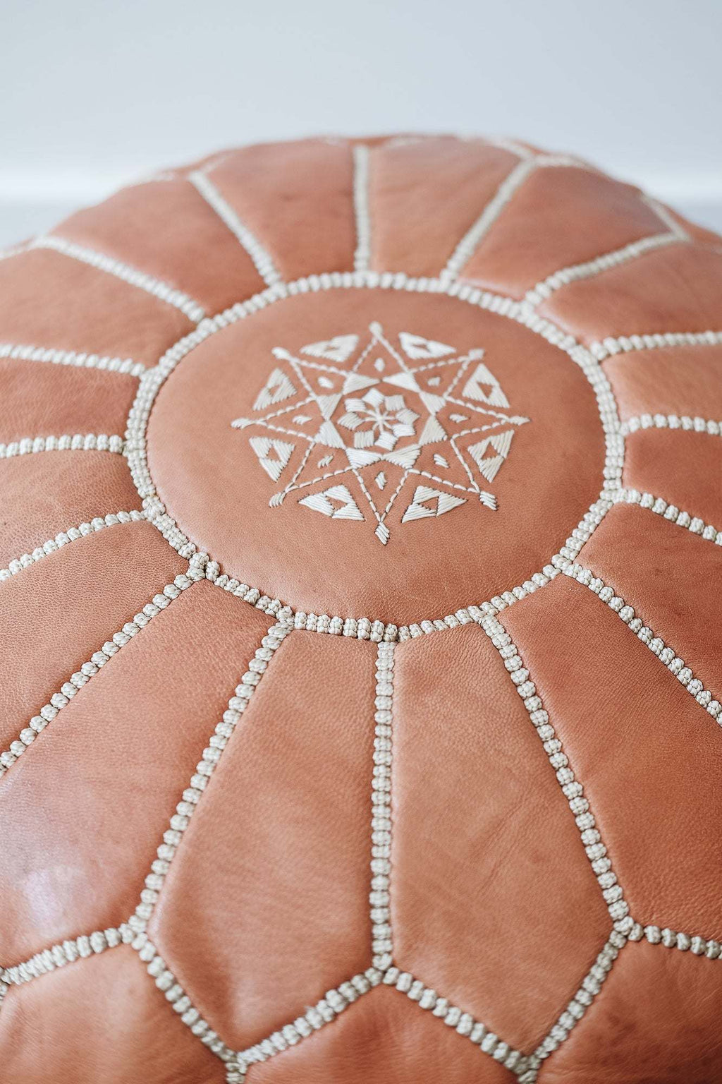 Embroidered Moroccan leather pouf with geometric stitched pattern and soft patina finish