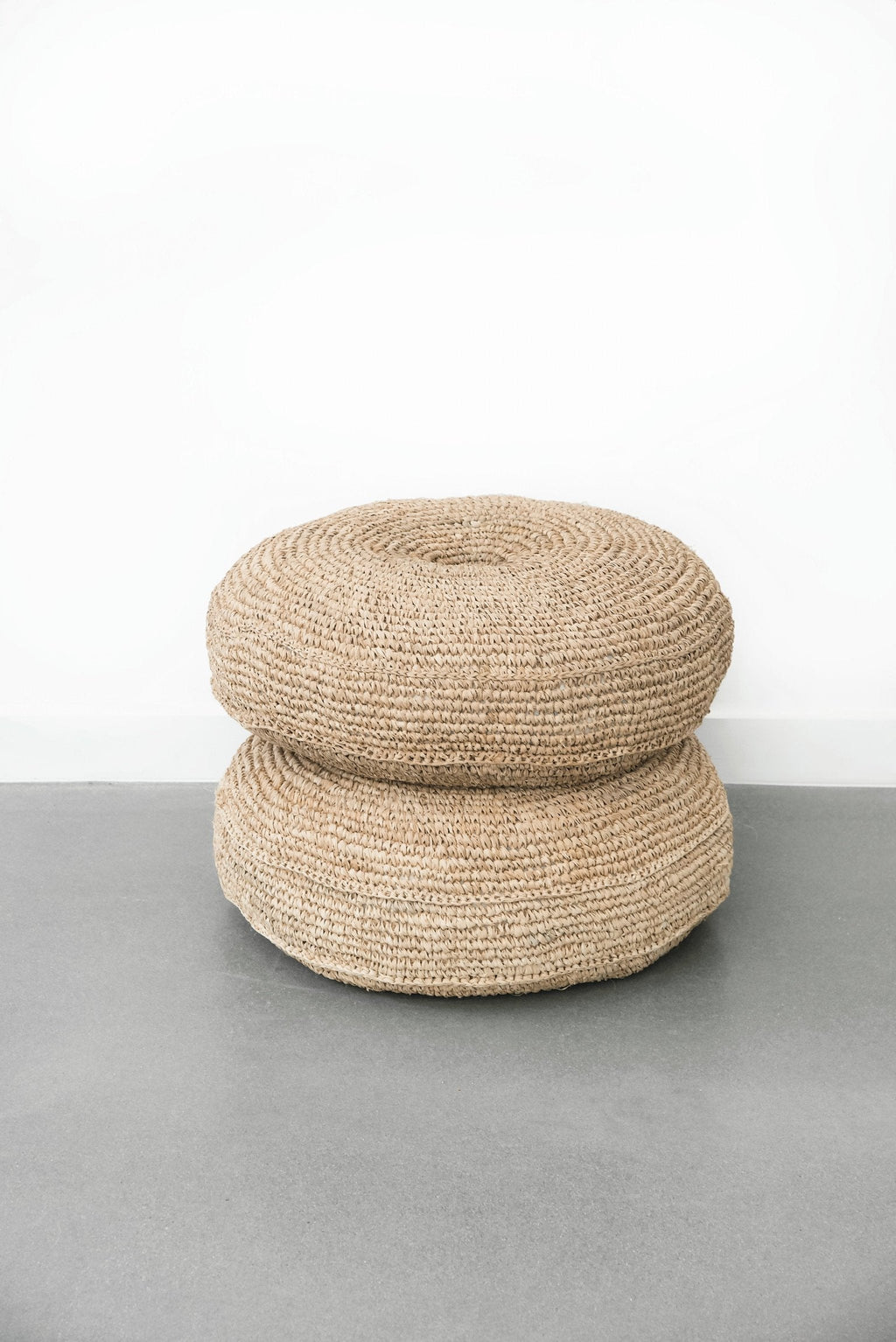 Natural woven hyacinth pouf with stacked design for seating or decor