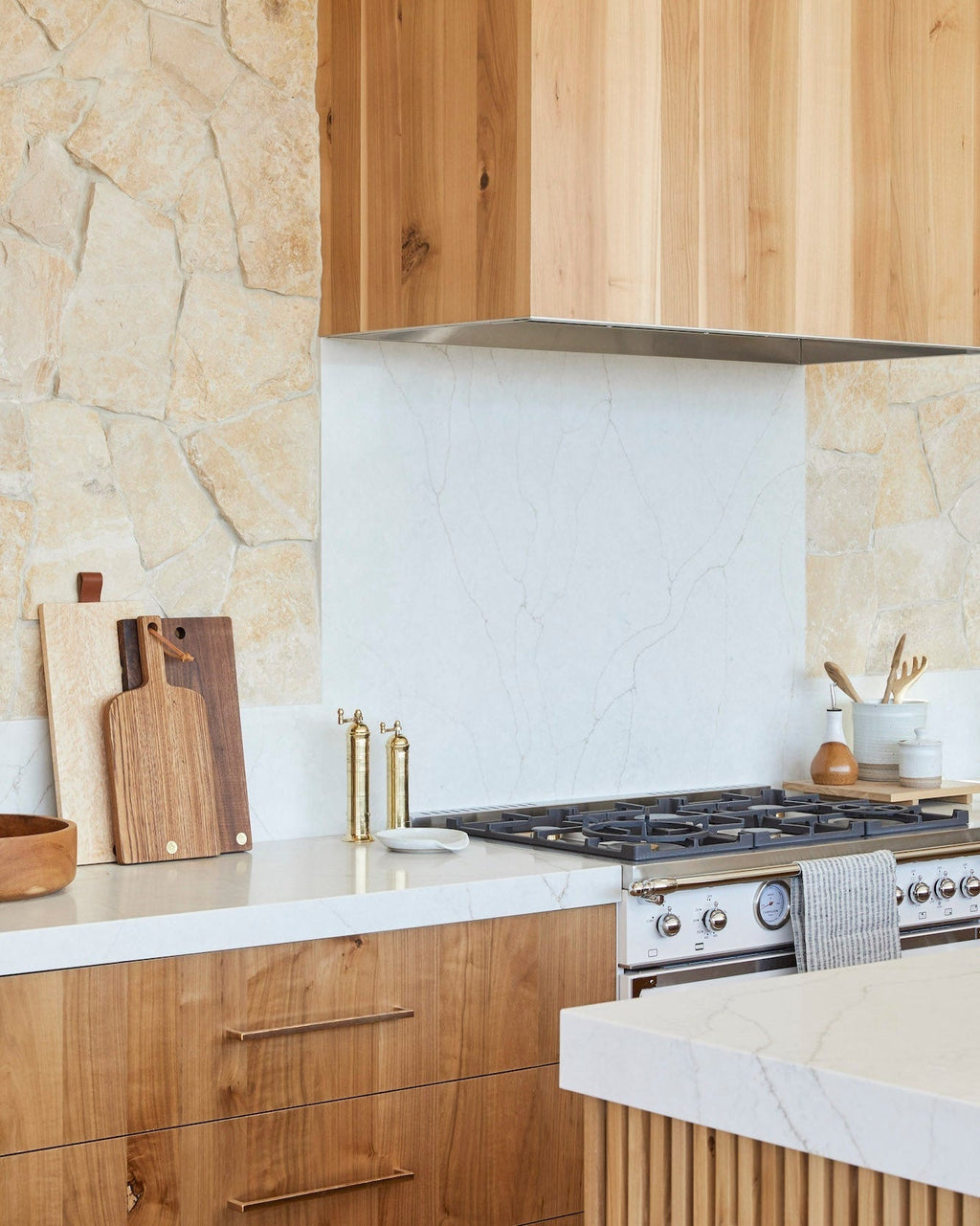 Atlas Brass Salt and Pepper Grinder Set on modern kitchen countertop with wooden cabinetry and stone backsplash