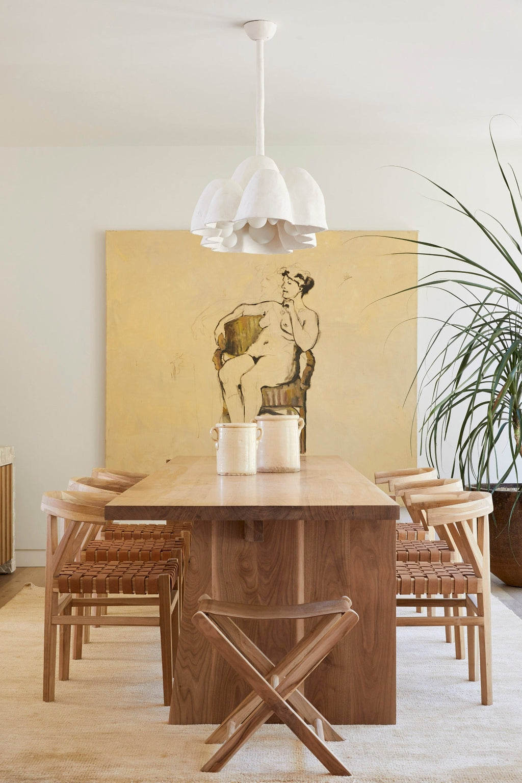 Woven leather wishbone dining chairs with hand-carved teak table in modern dining room